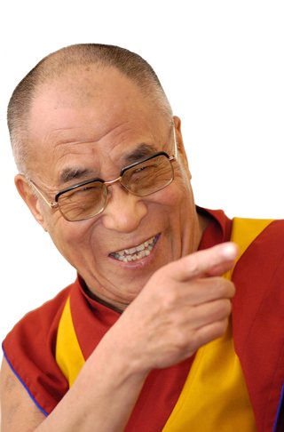 The Dalai Lama, smiling and pointing